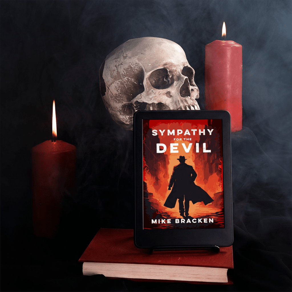 A tablet displaying the book cover of horror novel 'Sympathy for the Devil' by Mike Bracken, styled on a stack of books with a skull, a red candle, and a dark smoky background.