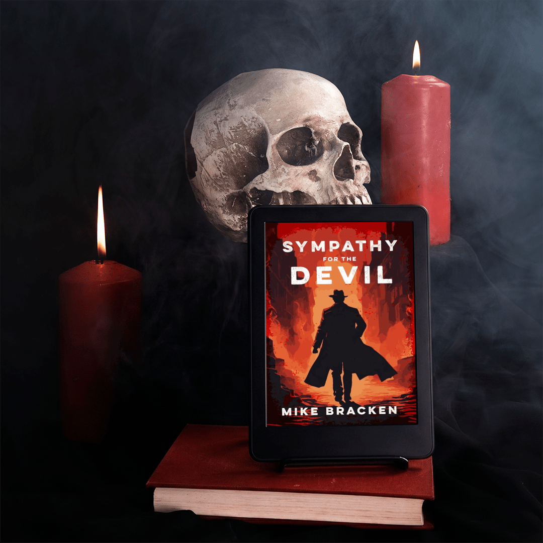 A tablet displaying the book cover of horror novel 'Sympathy for the Devil' by Mike Bracken, styled on a stack of books with a skull, a red candle, and a dark smoky background.